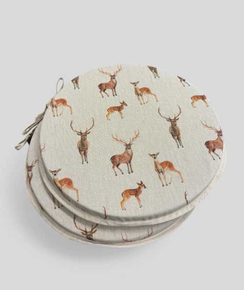Round linen style seat pads with a brown stag and deer design
